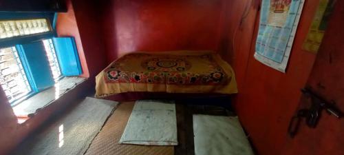 een kleine kamer met een bed en een raam bij Harish Homestay in Kapkot