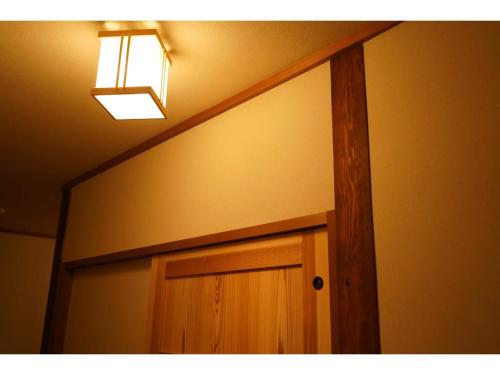 una porta in legno in una stanza con una luce sopra di essa di YAKATA - Vacation STAY 58651v a Yuzawa