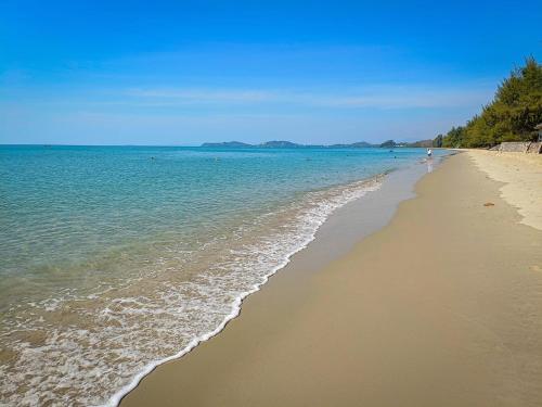 une plage de sable avec l'océan en arrière-plan dans l'établissement NADOHN Camper, à Ban Nam Lai Ta Tum