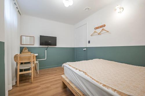 首爾的住宿－SSH Myeongdong Dongdo Hostel，一间卧室配有一张床、一张书桌和一台电视。