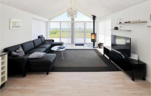 a living room with a black couch and a tv at Three-Bedroom Holiday Home In Sydals in Sarup