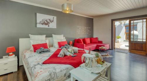 a bedroom with a large bed with red pillows at B&B Sauvignon Country Lodge in Wellington