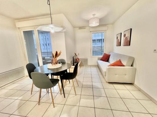 un salon avec une table et un canapé dans l'établissement Appartement T2 centre ville, balcon, à Bonneville
