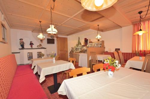 a restaurant with tables and chairs and a fireplace at Hotel Garni Viktoria in Sankt Anton am Arlberg