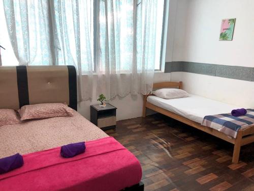 een slaapkamer met 2 bedden en een raam bij Alia Express CZ Hotel in Pasir Puteh