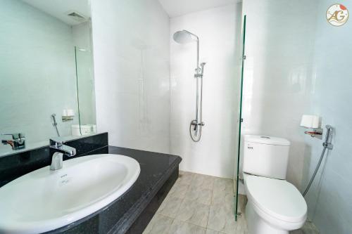 uma casa de banho branca com um lavatório e um WC em Tamundi Cao Bằng- An Gia Hotel- City Center em Hoàng Ngà