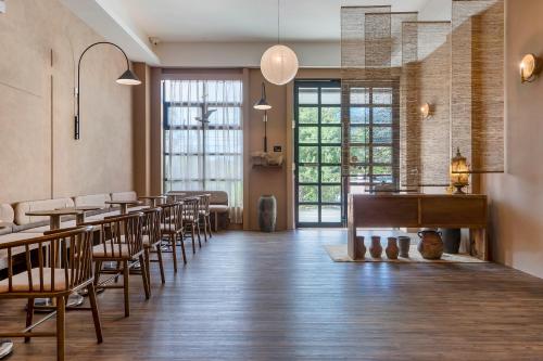 un restaurant avec des tables, des chaises et un piano dans l'établissement H& Kuma B&B, à Jian