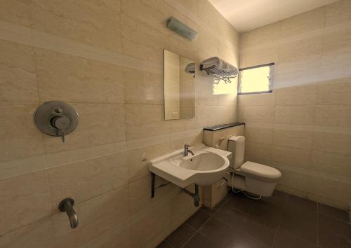 a bathroom with a sink and a toilet at RBS Residency in Tiruchchirāppalli