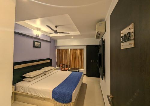 1 dormitorio con 1 cama y ventilador de techo en RBS Residency, en Tiruchchirāppalli