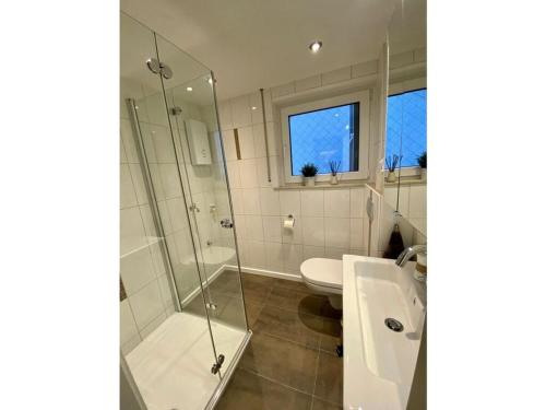uma casa de banho com um chuveiro, um WC e um lavatório. em Spacious apartment near ski-lift em NeuhÃ¼tten