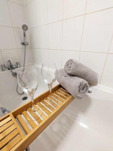 zwei Weingläser auf einem Regal in einer Badewanne in der Unterkunft Cosy Chic Ipswich Flat in Bramford