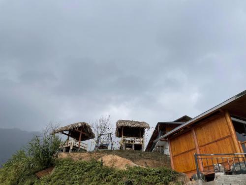 a group of huts on top of a hill at Homestay Chân Mây Chiêu Lầu Thi in Hoàng Su Phì