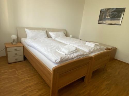 Una cama con sábanas blancas y almohadas en un dormitorio en Appartement 24, en Oerlinghausen