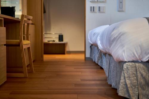 a bedroom with two beds and a wooden floor at Sanso Amanosato in Katsuragi