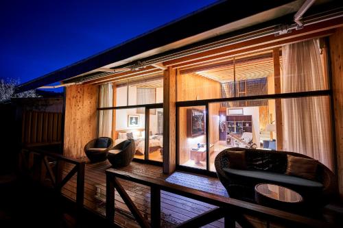 a balcony with chairs and a large window at Sanso Amanosato in Katsuragi