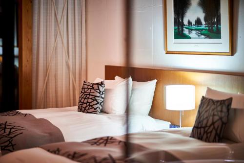 a hotel room with two beds and a lamp at Sanso Amanosato in Katsuragi