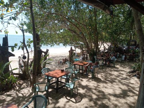 un gruppo di tavoli e sedie sulla spiaggia di Bangkaew Camping place bangalow a Krabi town