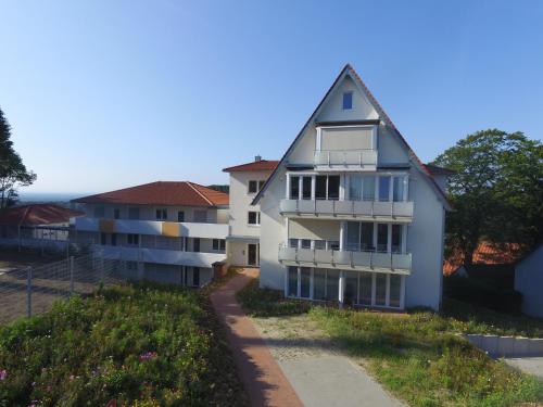 un edificio de apartamentos blanco con techo de gambrel en Appartement 24, en Oerlinghausen