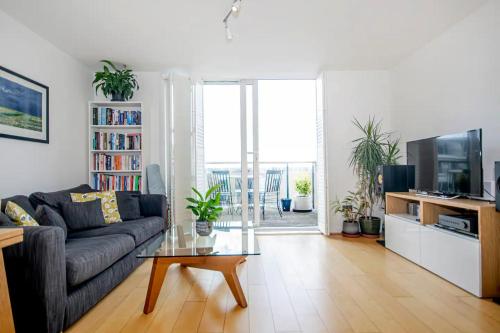 een woonkamer met een bank en een tv bij Renovu Exclusive Rooms London in Londen