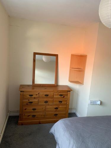 a bedroom with a dresser with a mirror on it at Double room Eastbourne in Polegate