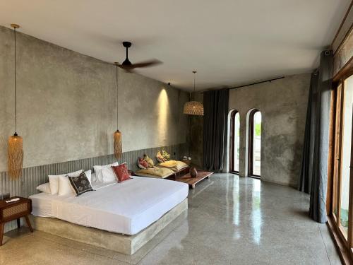 a bedroom with a large white bed and a couch at Be Zanzibar Boutique Hotel in Mfumbwi