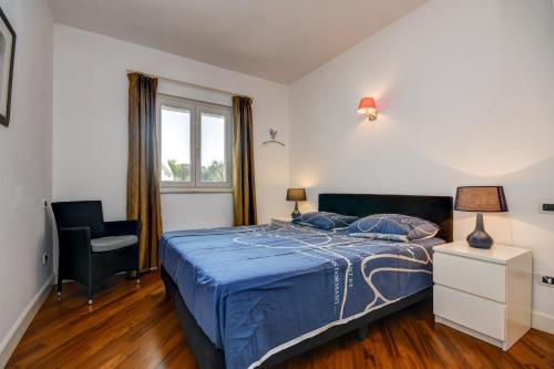 a bedroom with a bed and a chair and a window at Villa Erika in Manerba del Garda