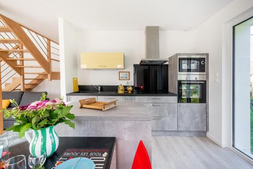 un salon avec une cuisine dotée d'un comptoir dans l'établissement Maison Odalphine - Calme et nature, à l'Île-aux-Moines