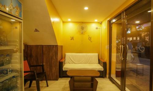 une petite chambre d'hôpital avec un lit et une table dans l'établissement Hotel Shantinivas, à Tarapith