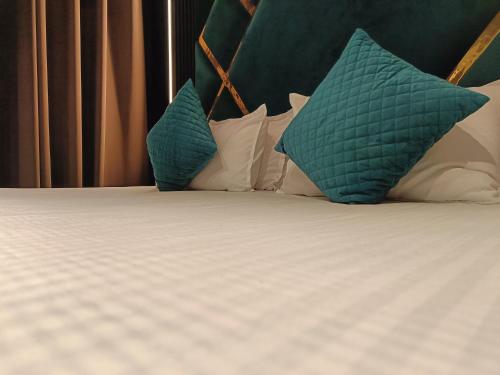 Una cama con almohadas verdes y blancas. en Lieu D Amour, en Srinagar