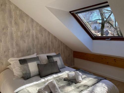 une chambre avec un grand lit avec une fenêtre dans l'établissement L’Orme • Duplex central au bord du canal, à Annecy