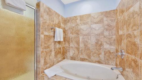uma casa de banho com uma banheira e um chuveiro em vidro. em Four Seasons em Lake Ozark