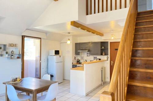 une cuisine et une salle à manger avec une table et des chaises dans l'établissement L’Orme • Duplex central au bord du canal, à Annecy