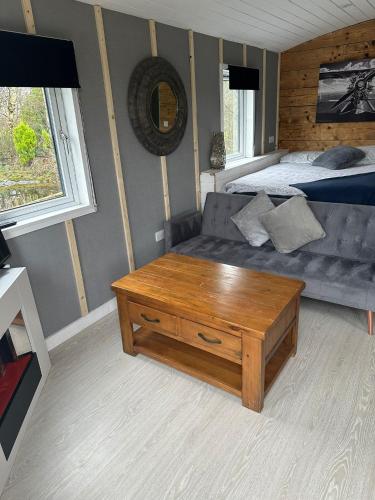 a living room with a couch and a table at Glamping Hut - Sleeps up to 4 Hot Tub & Parking in Welshpool