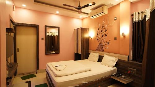 a bedroom with a bed and a mirror in it at Hotel Shantinivas - Tarapith in Tarapith