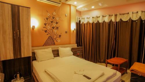 - une chambre avec un lit, une table et une chaise dans l'établissement Hotel Shantinivas, à Tarapith