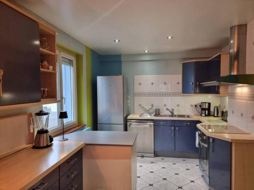 - une cuisine avec des appareils bleus et blancs dans une chambre dans l'établissement La Maison Chamarrée, à La Bresse