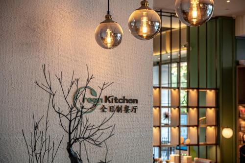 a wall with three lights and a tree on it at 深圳英威斯顿酒店 Investon Hotel Shenzhen in Lung Wa