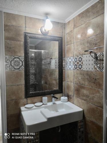 a bathroom with a sink and a mirror at Apartment Nina Holidays in Paralia Sikias