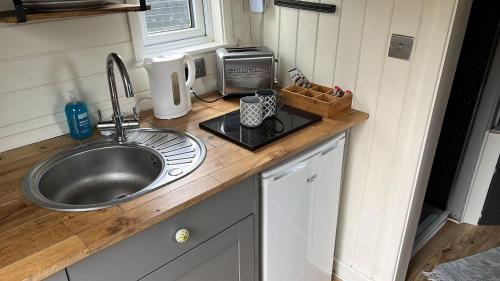 encimera de cocina con fregadero y fregadero en Glamping Hut - Riverside 2, en Welshpool
