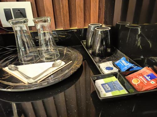 einem schwarzen Tisch mit zwei Glasvasen und einem Tablett in der Unterkunft Lieu D Amour in Srinagar