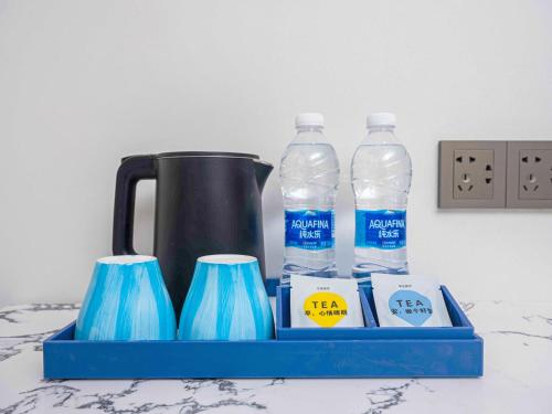 a tray with two bottles of water and two cups at Insail Hotels Guangzhou Beijing Road Pedestrian Branch in Guangzhou