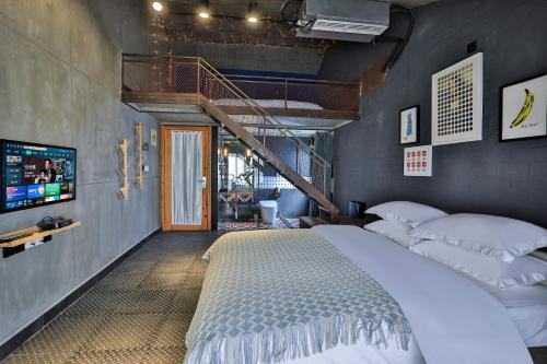 a bedroom with a large bed and a staircase at Wuzhen Qiuxi Art Hotel in Tongxiang