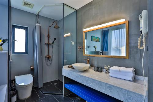 a bathroom with a sink and a mirror at Wuzhen Qiuxi Art Hotel in Tongxiang