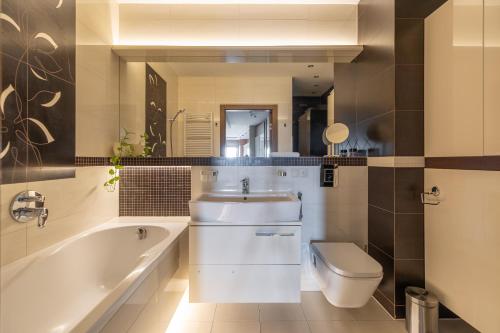 a bathroom with a tub and a sink and a toilet at Apartament francuski in Gdańsk