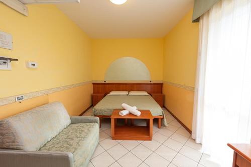 a room with a bed and a couch and a table at Hotel Roma Sul Mare in Roseto degli Abruzzi