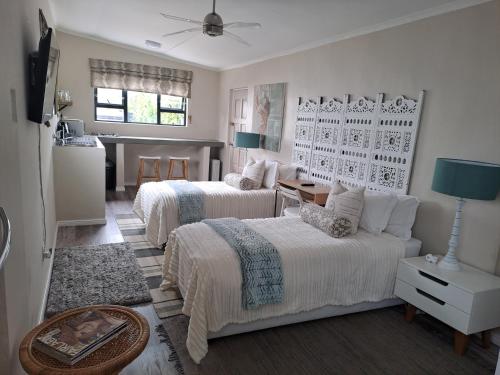 a bedroom with two beds and a living room at Milky Way in Hermanus