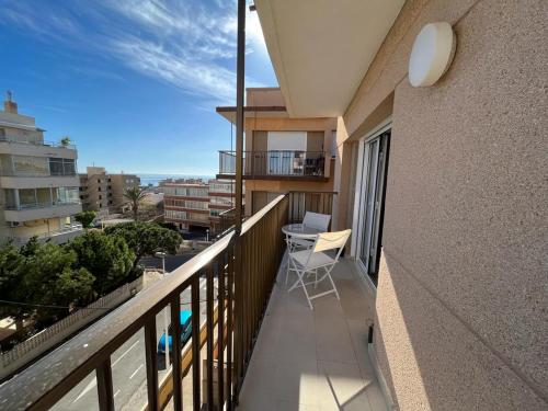 Marbella Sea View Apartament في آريناليس ديل سول: بلكونة مبنى مع طاولة وكراسي