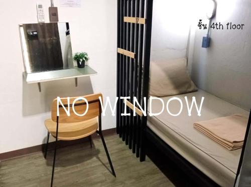 Zimmer mit einem Bett mit einem Stuhl ohne Fenster in der Unterkunft Feel good pinklao in Bangkok
