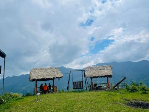 two people standing on a hill with a playground at Homestay Chân Mây Chiêu Lầu Thi in Hoàng Su Phì