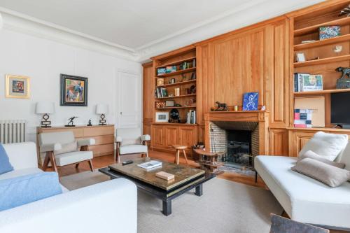 a living room with a couch and a fireplace at Luxury apartment for 6 people - Parc Monceau in Paris